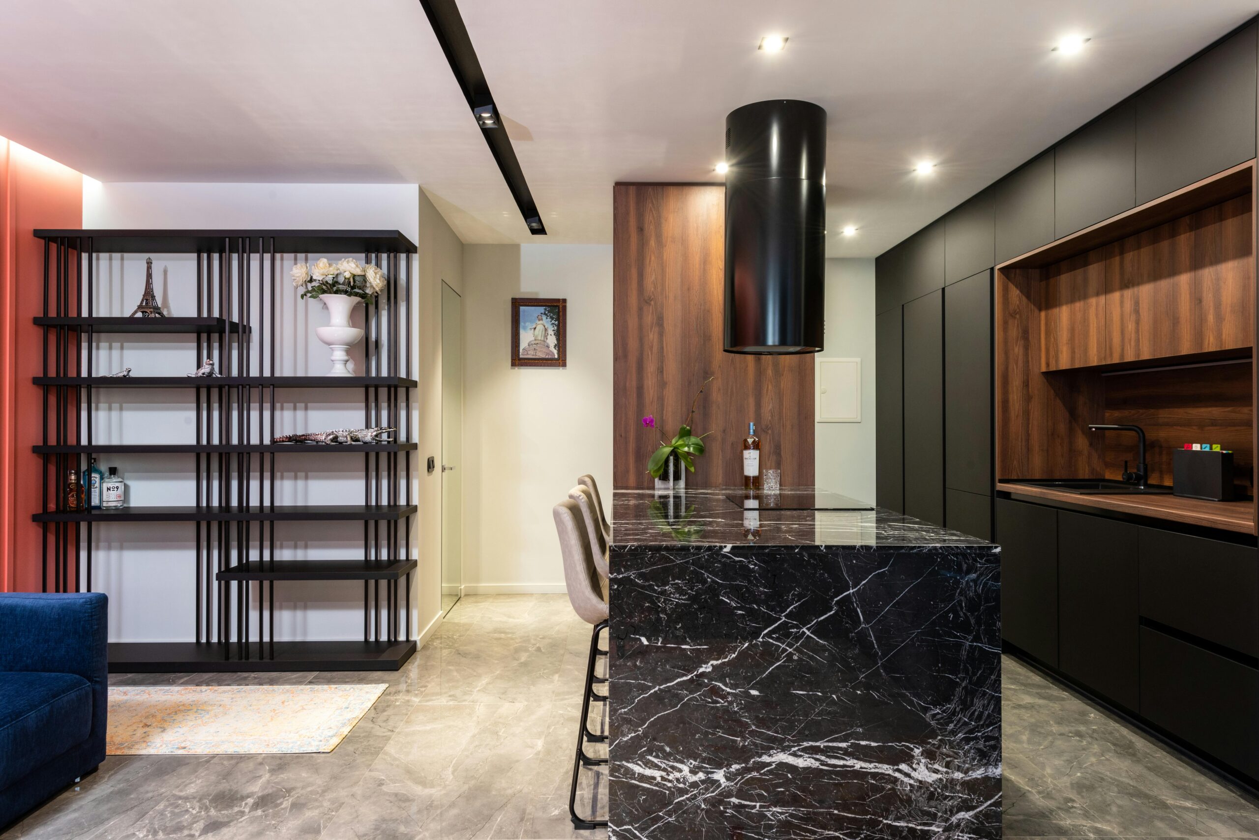Modern kitchen interior with black marble island and wooden cabinets, featuring a sleek design.